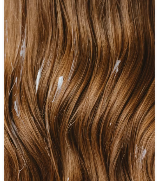 Brown water wave wig with defined S-shaped curls on a mannequin head
