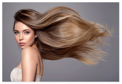 Beautiful woman with long, flowing balayage hair showcasing natural shine and movement